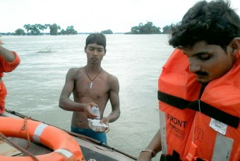 Food and water being transported in boats to flood affected villages